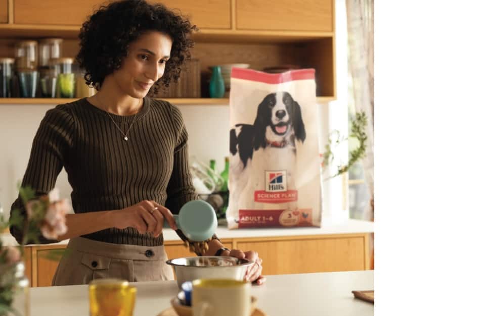 Una donna serve un alimento Hill's in una ciotola
